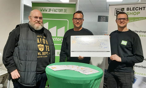 3P-Factory Das Bild zeigt drei Männer, die einen übergroßen Spendenscheck präsentieren. Der Scheck scheint von der Sparkasse zu sein und ist über einen Betrag von 2.000 Euro ausgestellt. Im Hintergrund sind Banner mit den Logos von