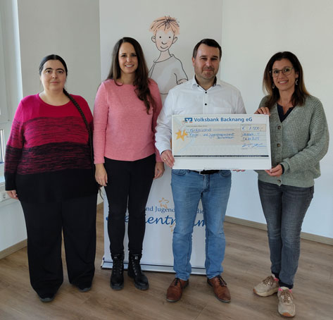 Das Bild zeigt vier Personen, die vor einem Banner mit der Aufschrift 